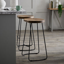 Load image into Gallery viewer, Franklin Hardwood Shaped Barstool in BROWN Hill Interiors 19924 5050140992494 Industrial styling Handcrafted Beautifully made and incredibly stylish Dimensions: 75cm x 40cm x 35cm Weight: 6.54kg Volume: 0.16CBM This is the Franklin Hardwood Shaped Barstool, it features a hardwood seat and complementing metal legs and frame. This bar stool design is hugely popular and would complement an extensive range of interiors including a kitchen, bar, restaurant or hotel. Featuring a shaped seat this barstool is a com