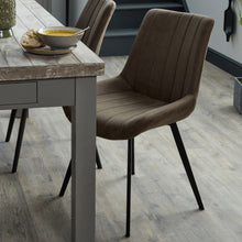 Load image into Gallery viewer, Malmo Grey Dining Chair in GREY Hill Interiors 20046 5050140004685 Scandi styling Handcrafted High quality faux leather Dimensions: 86cm x 49cm x 57cm Weight: 5.4kg Volume: 0.268CBM The Malmo Dining Chair is a handsome addition to a kitchen or dining space. It features a simple design which oozes practicality and comfort too wrapped up in a stylish, neutral grey package with black legs. Be sure to take a look at the tan version too, 20047.