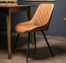 Load image into Gallery viewer, Oslo Tan Dining Chair in BROWN Hill Interiors 21244 5050140124482 Scandi styling Handcrafted A contemporary feel Dimensions: 82cm x 48cm x 60cm Weight: 5.2kg Volume: 0.22CBM This is the Oslo Tan Dining Chair. Featuring supple tan upholstery, the Oslo Dining Chair exudes understated elegance, while its diamond-stitched detailing adds a luxurious aesthetic. The warm tan hue complements a variety of decor styles, adding a cosy and inviting ambiance to your dining space.
