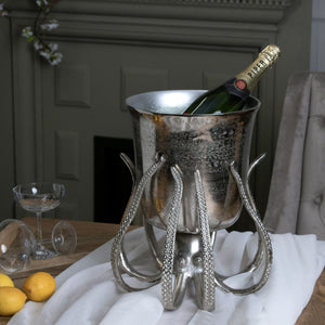Large Octopus Champagne Bucket in SILVER Hill Interiors 22235 5050140223581 Dimensions: 38cm x 36cm x 36cm Weight: 4.5kg Volume: 0.06CBM This is the Large Octopus Champagne Bucket. A stylish and beautifully detailed silver octopus, holds a handcrafted champagne bucket overhead for you to cool and serve your favourite bubbles from. Individually handcrafted with beautiful detailing, it will elevate any occasion. Simply fill with your favourite bubbles and enjoy!