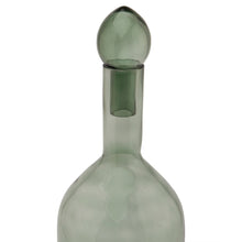 Load image into Gallery viewer, Smoked Sage Glass Tall Bottle With Stopper in SAGE Hill Interiors 22980 5050140298084 Dimensions: 43cm x 13cm x 13cm Weight: 0.72kg Volume: 0.07CBM This is the Smoked Sage Glass Tall Bottle With Stopper. This ornamental glassware is a perfect partner to our new Stamford furniture range, injecting some subtle and soothing tones to its display cabinets and surfaces. Matching alternate shape available for a beautiful staggered height display.