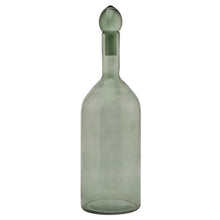 Load image into Gallery viewer, Smoked Sage Glass Tall Bottle With Stopper in SAGE Hill Interiors 22980 5050140298084 Dimensions: 43cm x 13cm x 13cm Weight: 0.72kg Volume: 0.07CBM This is the Smoked Sage Glass Tall Bottle With Stopper. This ornamental glassware is a perfect partner to our new Stamford furniture range, injecting some subtle and soothing tones to its display cabinets and surfaces. Matching alternate shape available for a beautiful staggered height display.