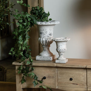 Fluted Stone Ceramic Urn in STONE Hill Interiors 22984 5050140298480 Dimensions: 25cm x 20cm x 20cm Weight: 2kg Volume: 0.07CBM This is the Fluted Stone Ceramic Urn. Sculptural and impactful, this stylish stone effect urn is everything an entryway needs for instant wow-factor. Display it as is or fill with faux florals to make a lasting impression. Matching larger size urn available.