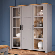 Load image into Gallery viewer, Bohol Large Display Cabinet in Riviera Oak/Grey Oak Furniture To Go 801bhlv631-m478 5904767835118 The Bohol collection draws inspiration from its timeless charm and rustic style, embracing its simplicity and natural elegance. What truly sets this collection apart from others is its exquisite decor - featuring three colourways with an Oak finish. The subtle elegance of the light Riviera Oak contributes by adding a focal point to each piece. Also featuring black handles with soft close doors, making it truly 