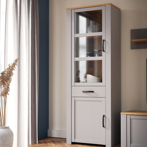Bohol Narrow Display Cabinet in Riviera Oak/Grey Oak Furniture To Go 801bhlv712-m478 5904767835125 The Bohol collection draws inspiration from its timeless charm and rustic style, embracing its simplicity and natural elegance. What truly sets this collection apart from others is its exquisite decor - featuring three colourways with an Oak finish. The subtle elegance of the light Riviera Oak contributes by adding a focal point to each piece. Also featuring black handles with soft close doors, making it truly