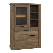 Load image into Gallery viewer, Corona Display Cabinet in Tabak Oak Furniture To Go 801cr2v521l-d64 5904767852689 Discover the captivating allure of the Corona collection, where practicality meets sophistication, the collection offers open recesses, drawers, doors, and shelves. Provide secure and stylish storage solutions with this high-quality selection of furniture. Dimensions: 2120mm x 1084mm x 413mm (Height x Width x Depth) 
 Traditional design 
 Dark warm tabak oak effect 
 , 1 glass door 
 1 drawer 
 3 shelves 
 Optional Lighting 
 