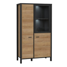 Load image into Gallery viewer, High Rock Small Display Cabinet in Matt Black/Riviera Oak Furniture To Go 801hrkv521-m197 5904767827199 High Rock, a captivating and contemporary collection which has a perfect blend of the Riviera Oak decor with deep black accents, this collection immediately captivates attention with its originality. The sleek black metal handles add a touch of elegance, while the tables boast robust metal legs in a frame-like design, contributing to a distinct loft character within the space. Beyond its striking aestheti