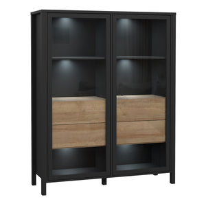 High Rock Extra Wide Display Cabinet in Matt Black/Riviera Oak Furniture To Go 801hrkv522-m197 5904767825508 High Rock, a captivating and contemporary collection which has a perfect blend of the Riviera Oak decor with deep black accents, this collection immediately captivates attention with its originality. The sleek black metal handles add a touch of elegance, while the tables boast robust metal legs in a frame-like design, contributing to a distinct loft character within the space. Beyond its striking aes